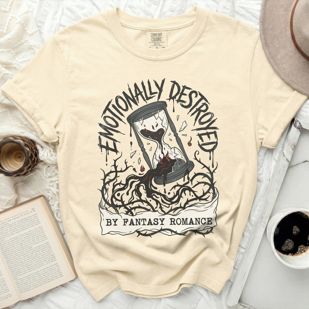Cream t-shirt with "Emotionally Destroyed By Fantasy Romance" graphic.