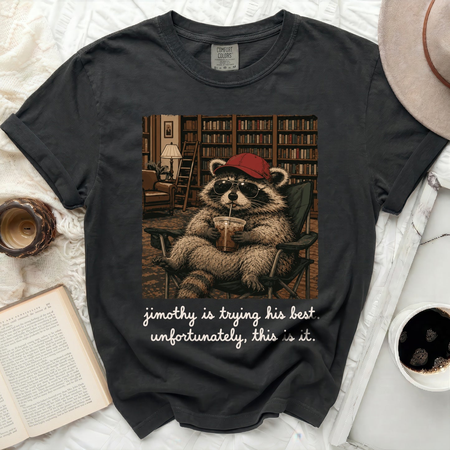 Black t-shirt with a raccoon wearing sunglasses and a hat, holding a drink.
