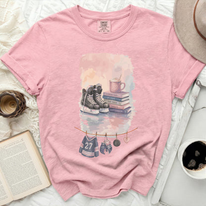 Pink t-shirt with hockey theme watercolor art: skates, puck, gloves, and jersey.