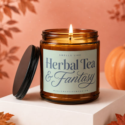 Amber candle with a lit wick labeled "Herbal Tea & Fantasy".