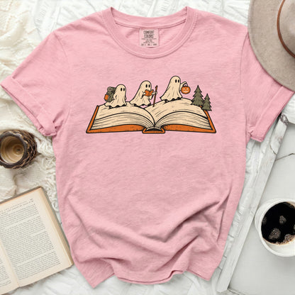Pink t-shirt with three ghosts on an open book, one with a backpack.