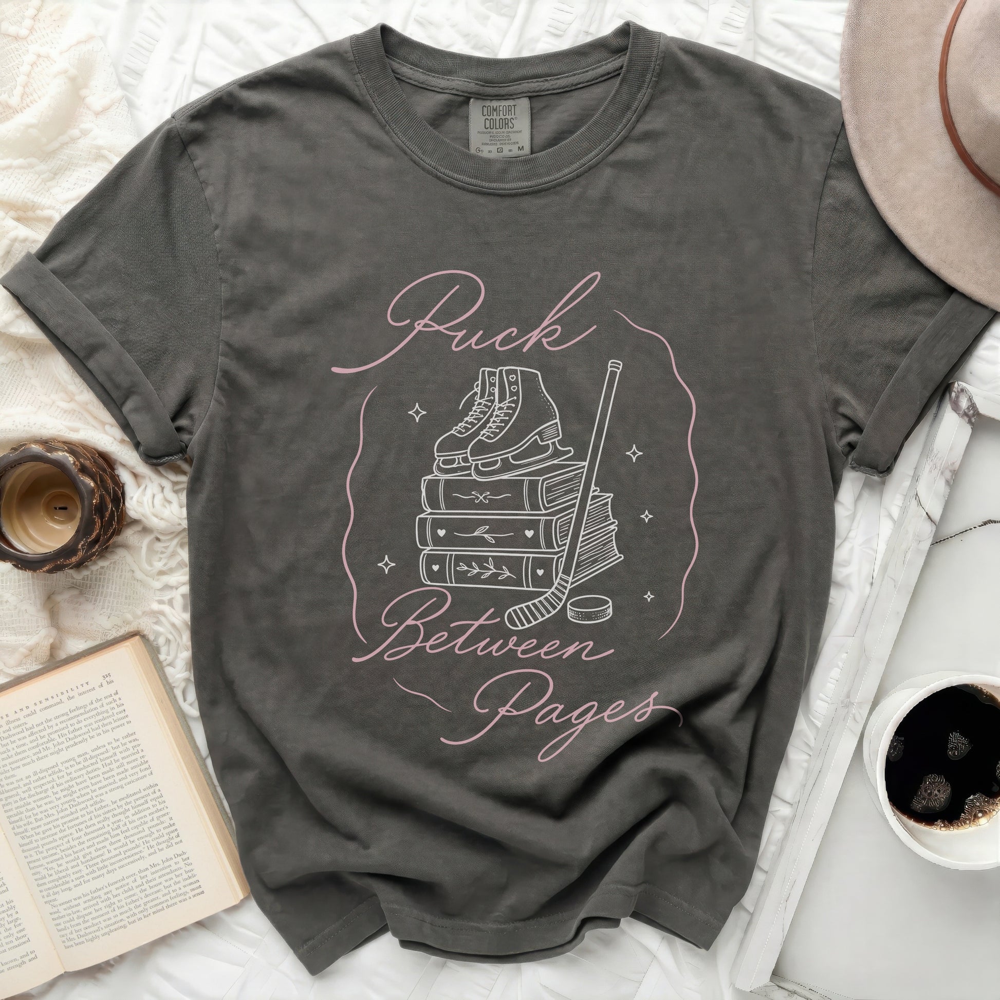 Dark gray t-shirt with "Puck Between Pages" text and graphics.