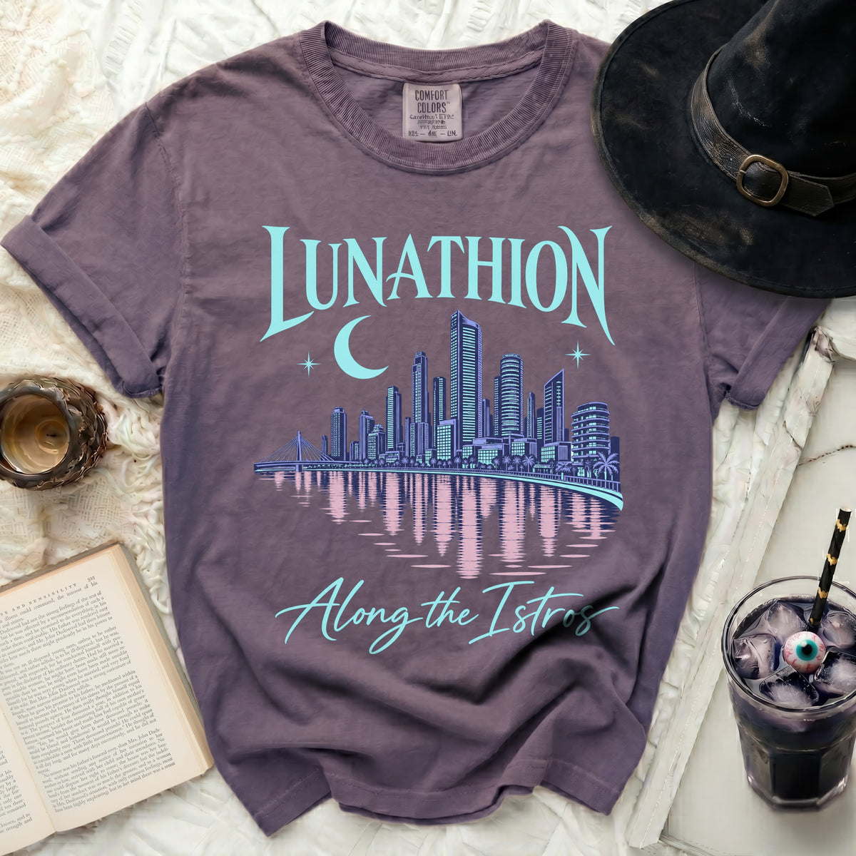 Purple t-shirt with "Lunathion Along the Istros" text and city skyline graphic.
