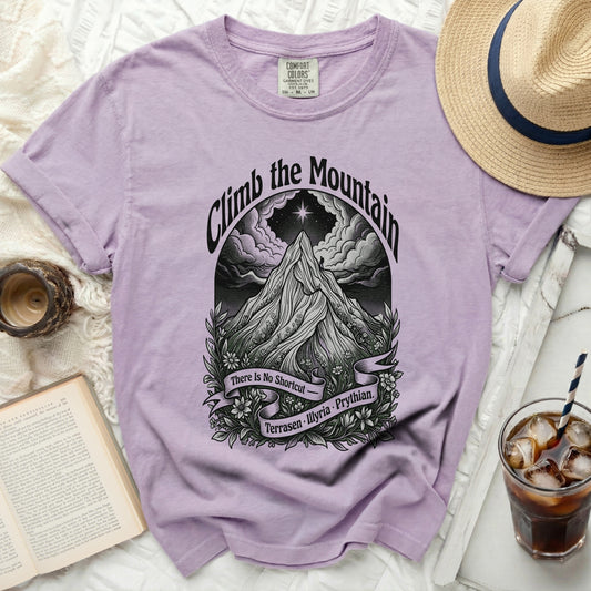 Purple t-shirt with "Climb the Mountain" graphic, featuring a mountain, clouds, and banner.