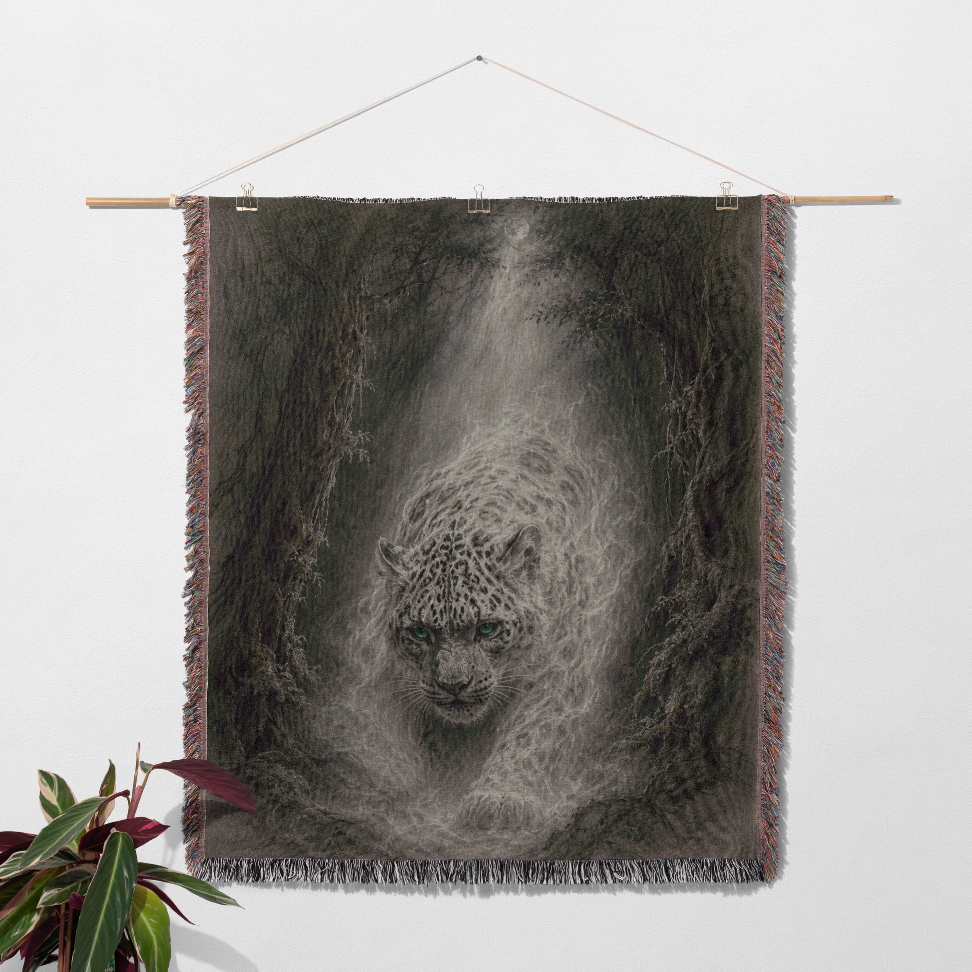 a large tapestry hanging on a wall, depicting a white leopard with a dark background.