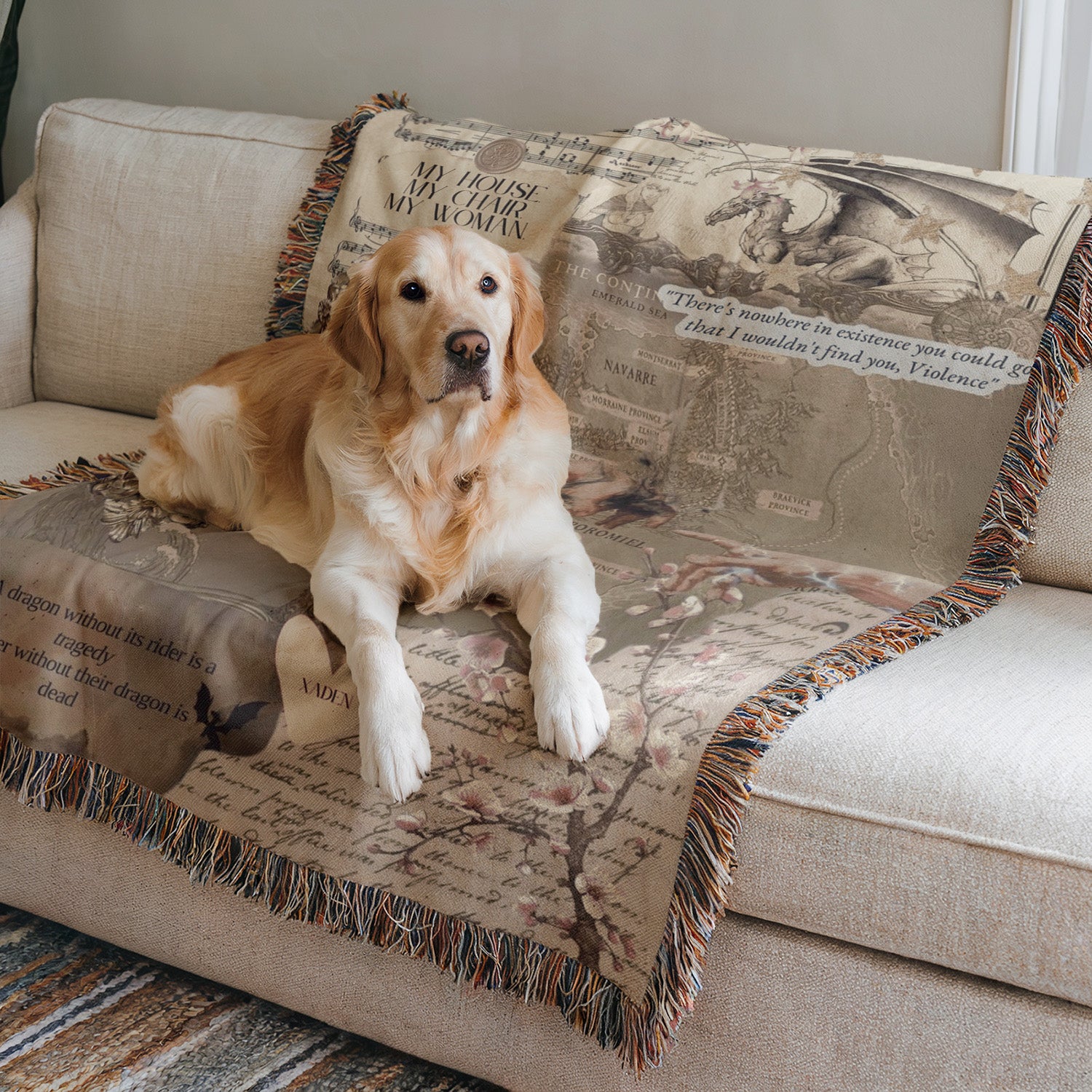 A golden retriever dog is sitting on a couch, resting on a decorative blanket with a map and text.
