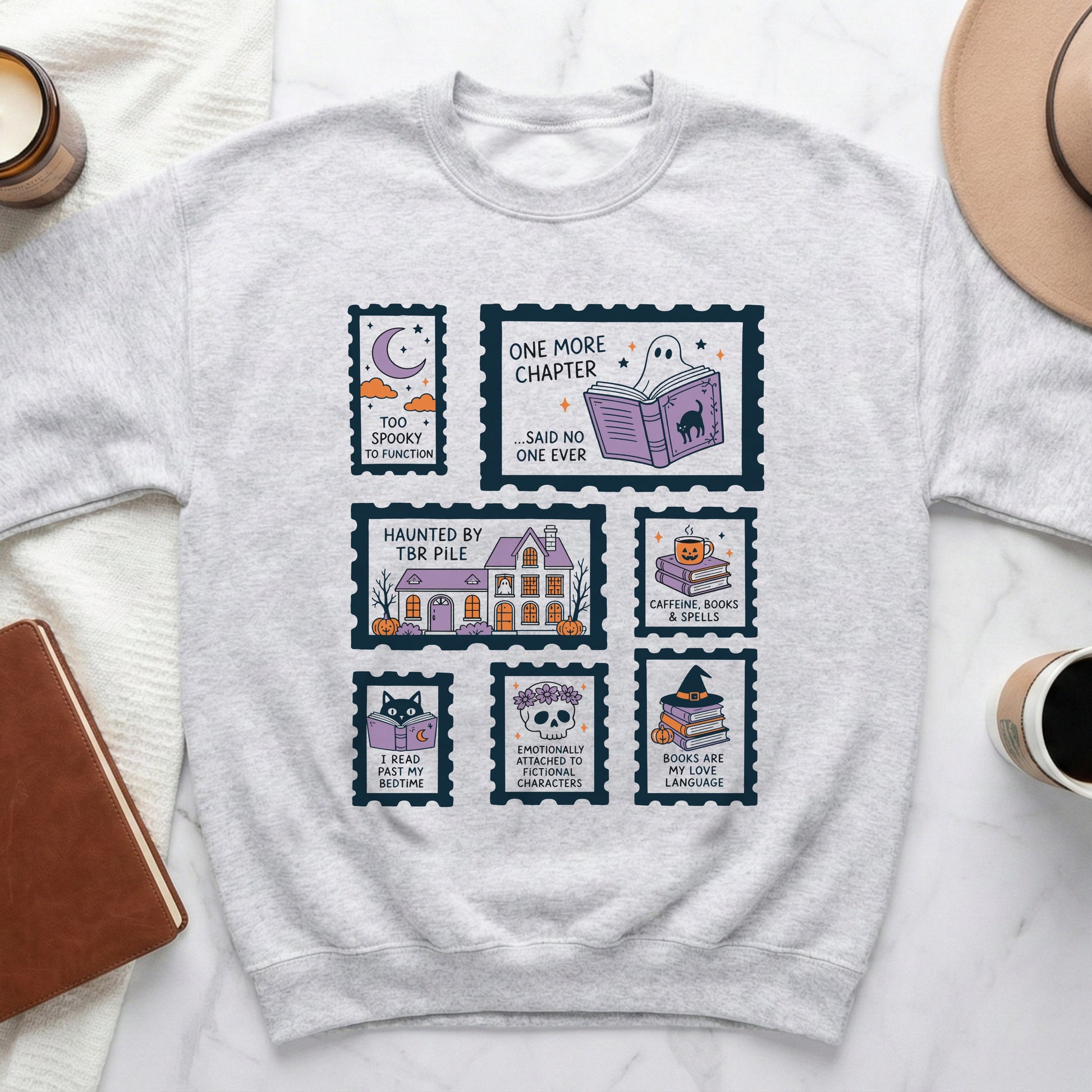 Light gray crewneck sweatshirt with stamp-like graphics featuring spooky and book-themed designs.