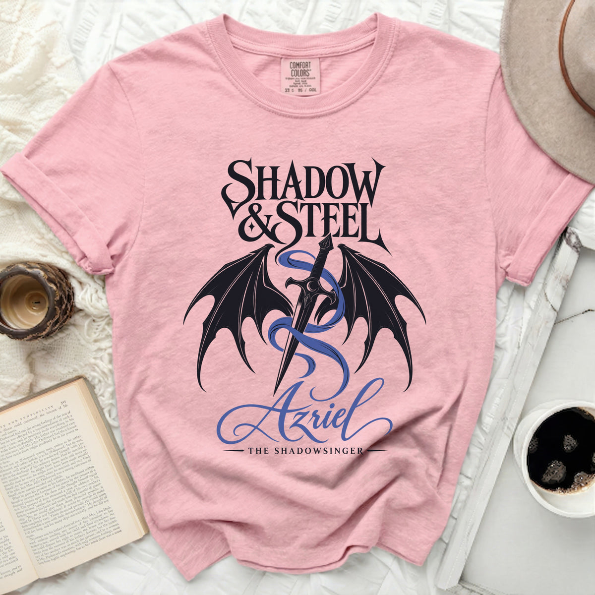 Pink shirt with Shadow & Steel and Azriel the Shadowsinger graphic.