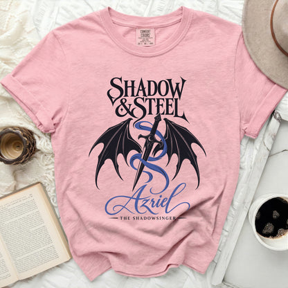 Pink shirt with Shadow & Steel and Azriel the Shadowsinger graphic.
