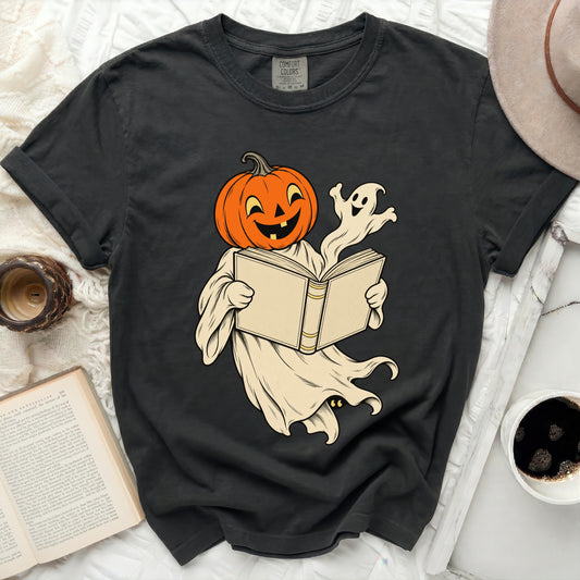 Black t-shirt with a Halloween graphic of a pumpkin-headed ghost reading a book.