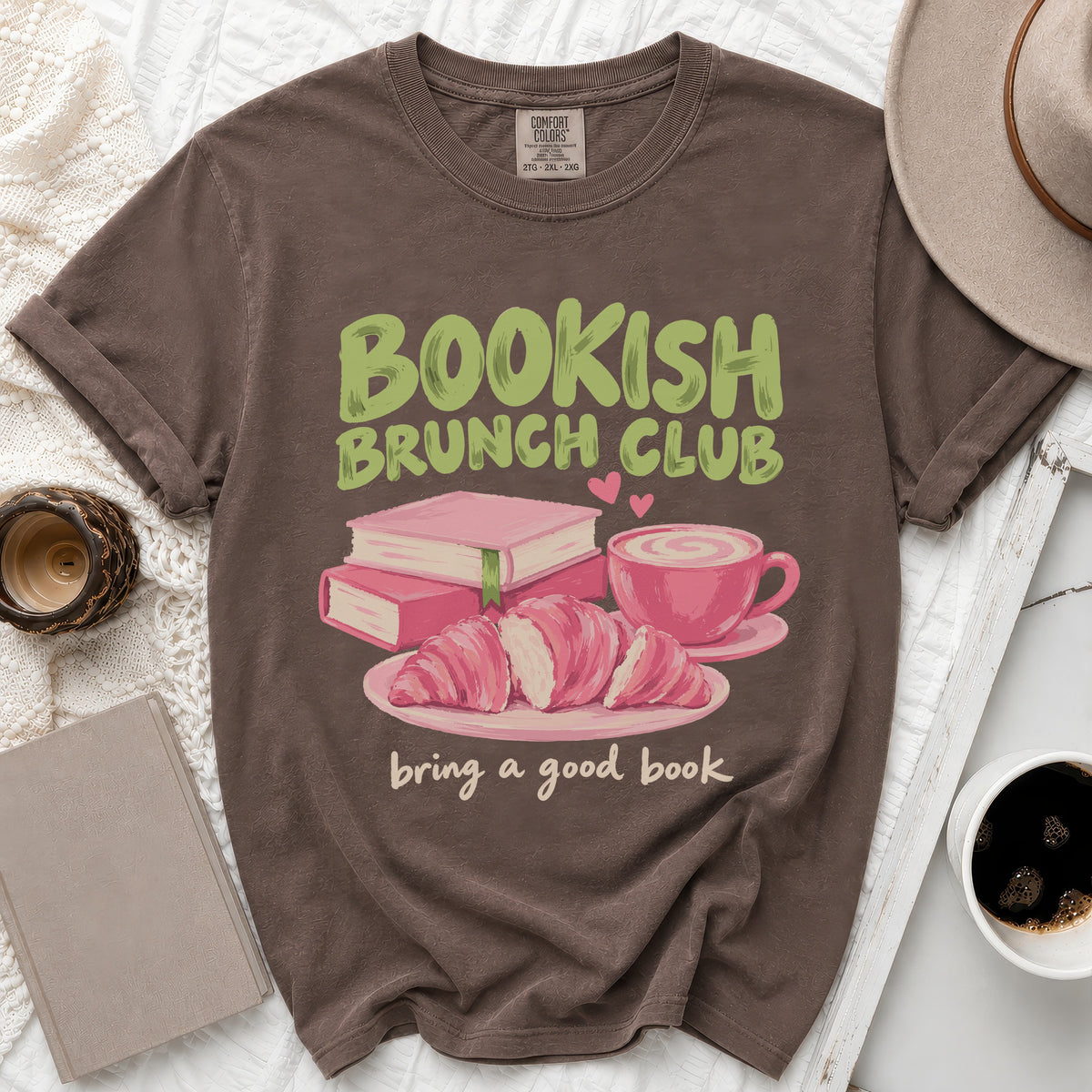 Brown t-shirt with "Bookish Brunch Club" text, books, croissants, and coffee.