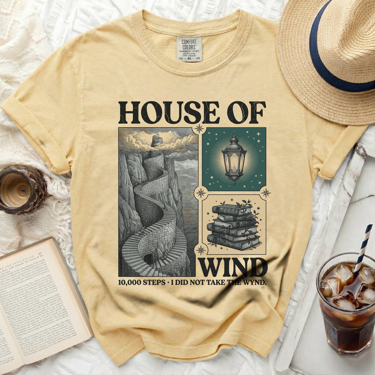 Yellow t-shirt with "House of Wind" graphic and a winding staircase.