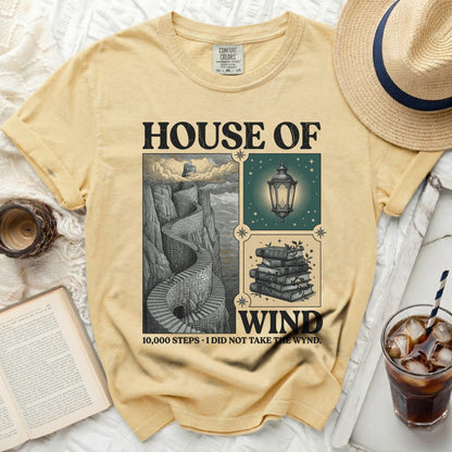 Yellow t-shirt with "House of Wind" graphic and a winding staircase.