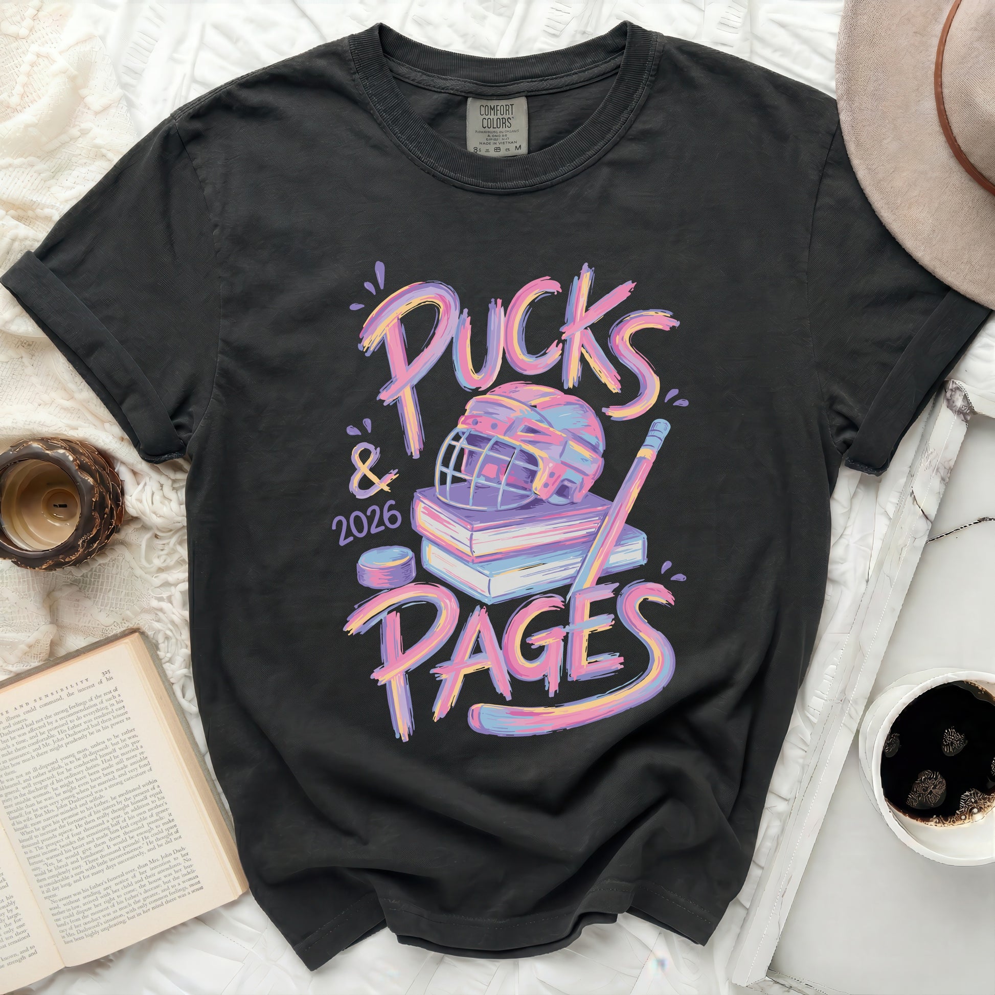 T-shirt with "Pucks & 2026 PAGES" text, hockey puck, and books.