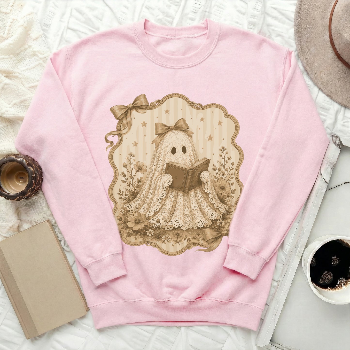 Pink pullover sweatshirt with a lace ghost reading a book graphic.