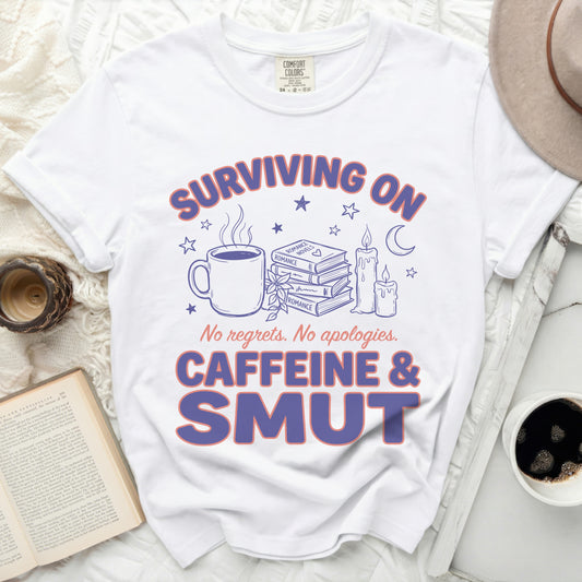 White t-shirt with "Surviving on Caffeine & Smut" graphic.