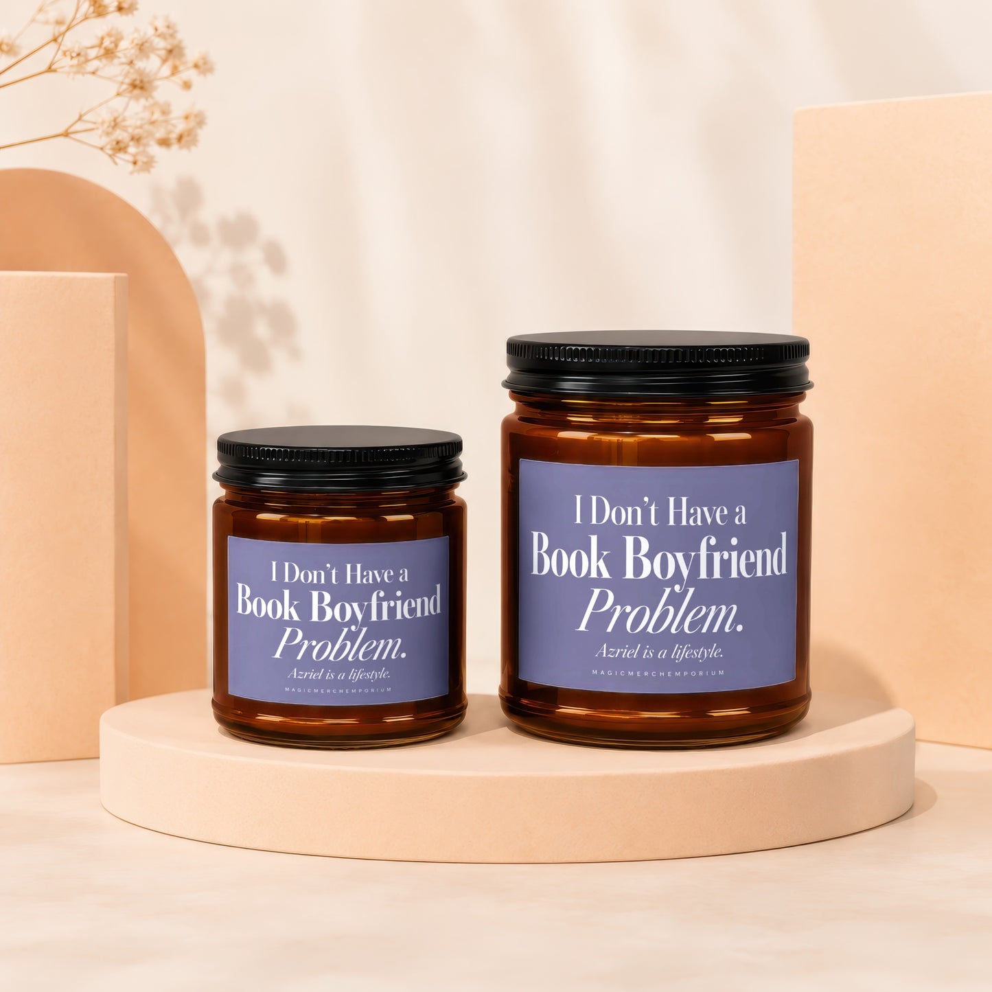 Two amber glass candle jars with black lids and purple labels reading I Don’t Have a Book Boyfriend Problem.
