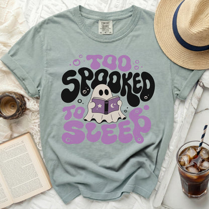 Ghost reading a book, "Too Spooked to Sleep" graphic tee.