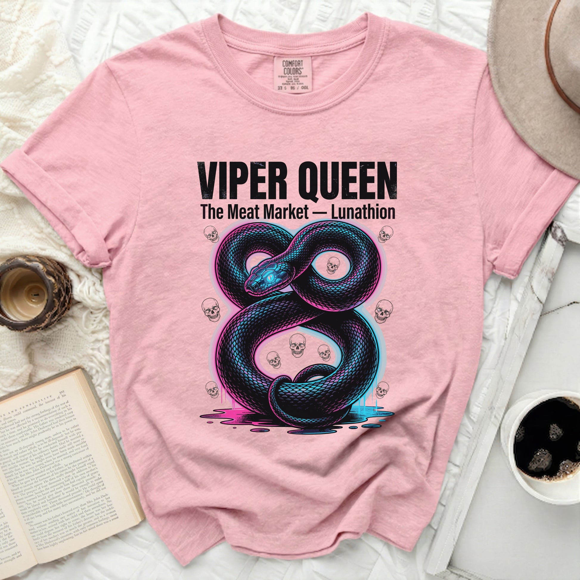 Pink t-shirt with neon snake and skulls graphic and text.