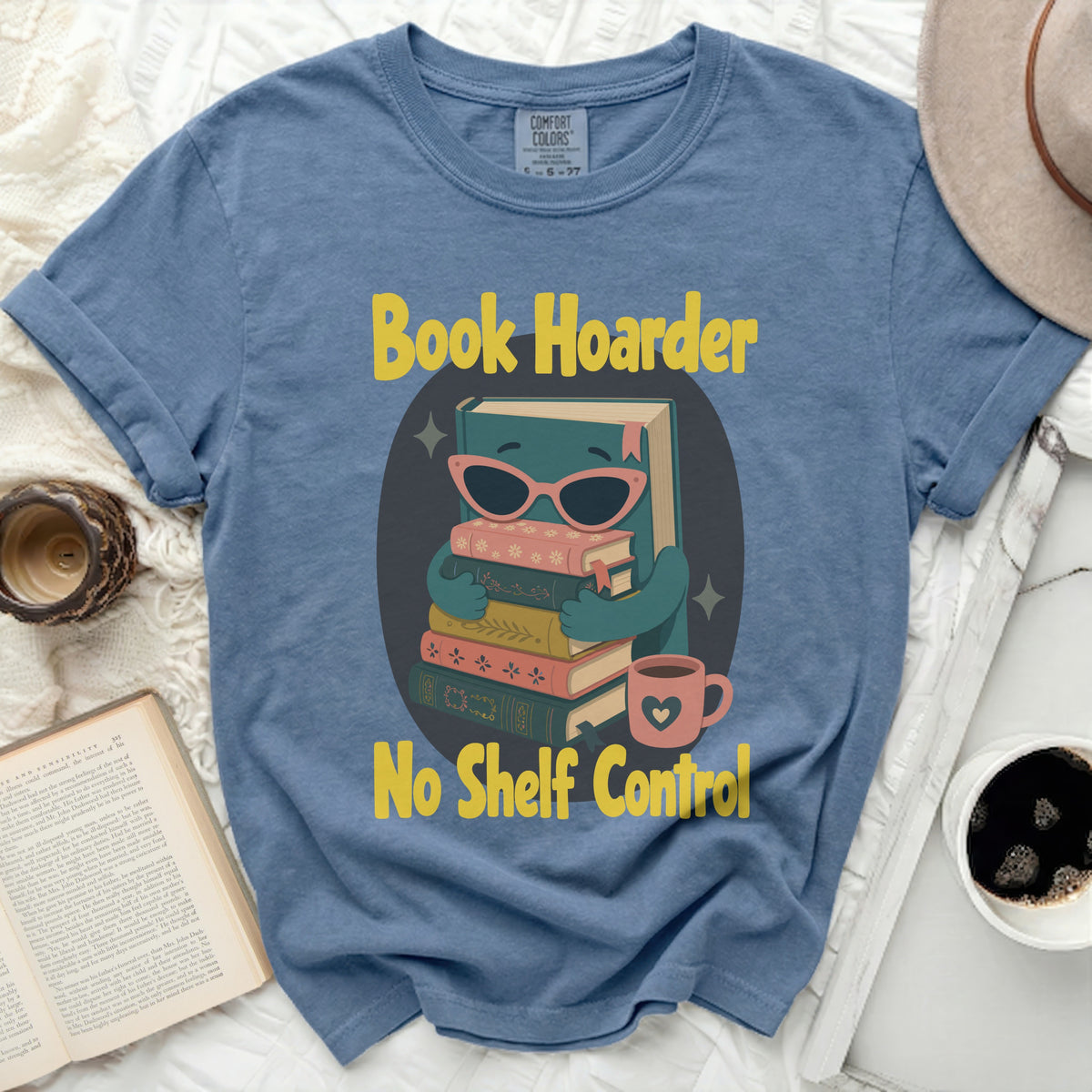 Blue t-shirt with cartoon book character and text "Book Hoarder No Shelf Control".