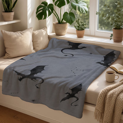 Grey blanket with scattered black dragons and constellation patterns.