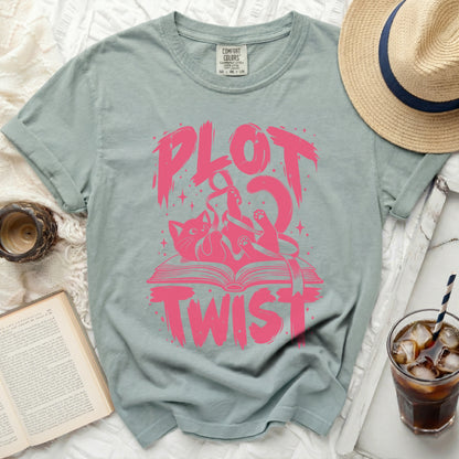 Light green t-shirt with pink "PLOT TWIST" text and a cat on a book graphic.