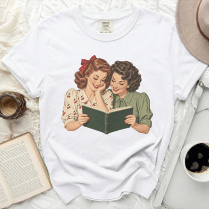 Vintage illustration of two women reading a green book, printed on a white t-shirt.