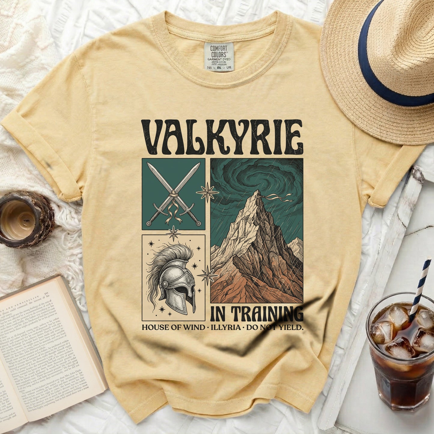 Valkyrie in training t-shirt with sword, helmet, and mountain illustrations.