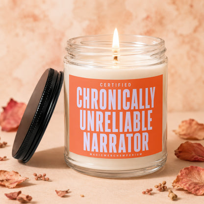 Glass candle with orange label reading "CERTIFIED CHRONICALLY UNRELIABLE NARRATOR"