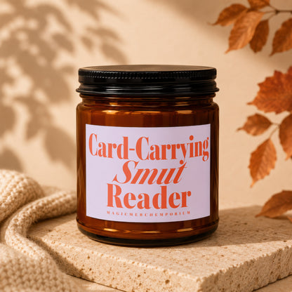 Amber jar candle with "Card-Carrying Smut Reader" text.