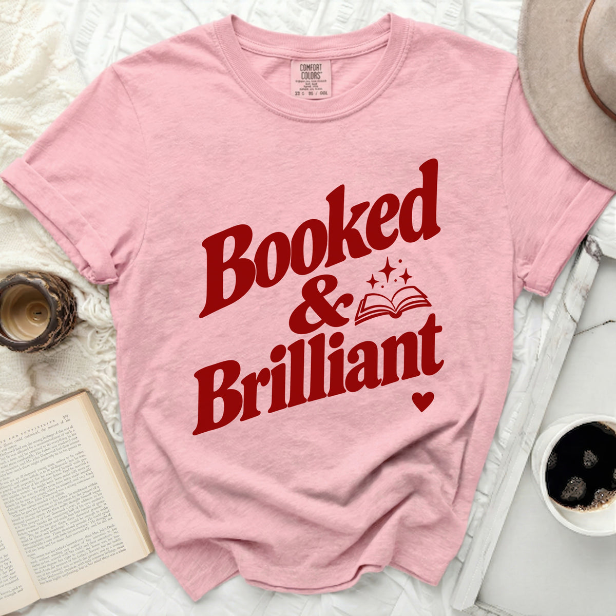 Pink t-shirt with red text "Booked & Brilliant" and a book graphic.