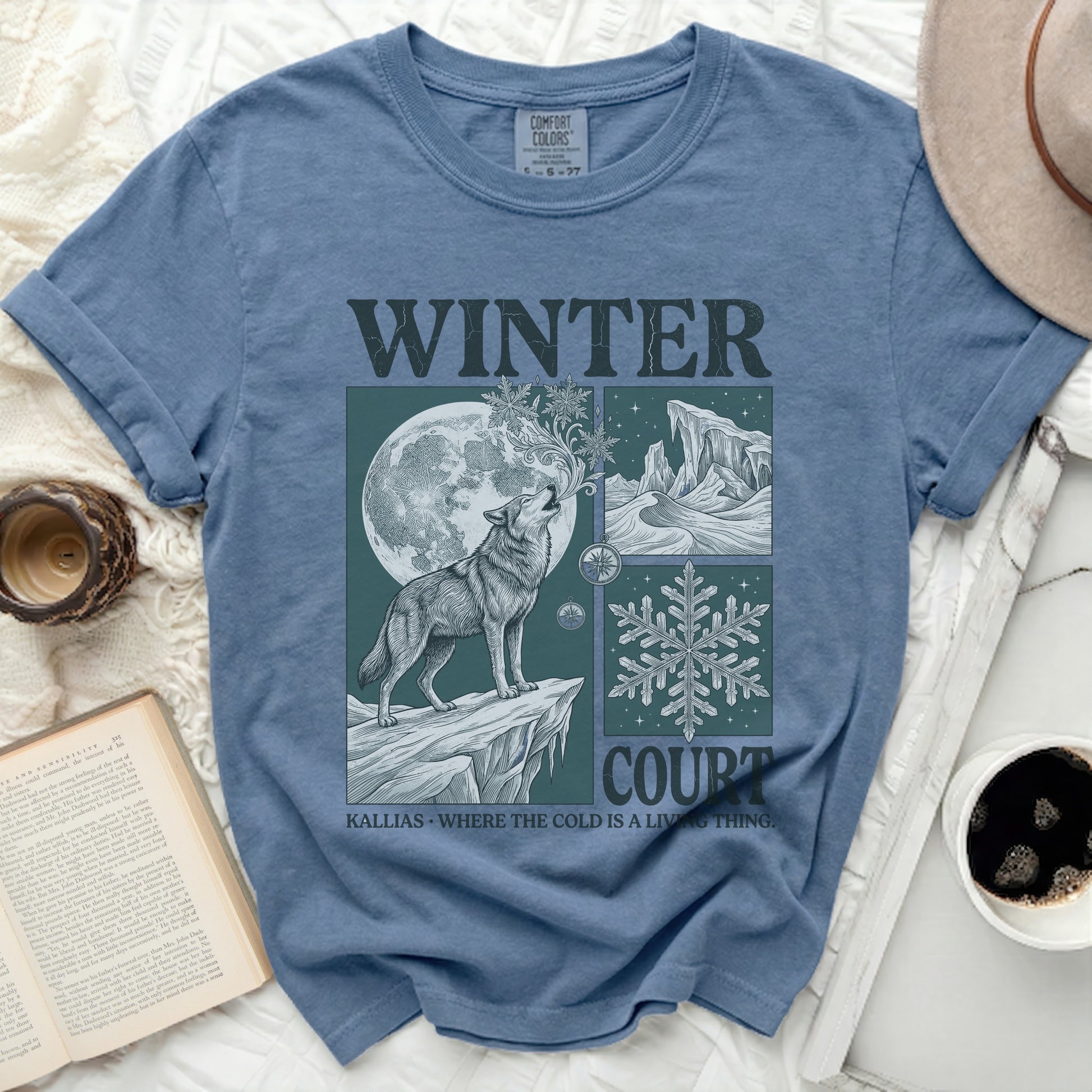 Blue t-shirt with a graphic of a wolf howling at the moon and the words "WINTER COURT".