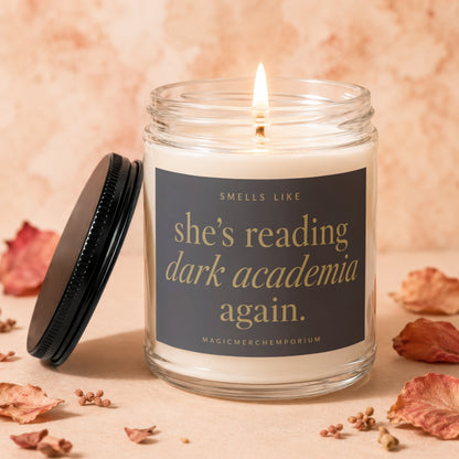 Candle with lit wick, reads "Smells like she's reading dark academia again."