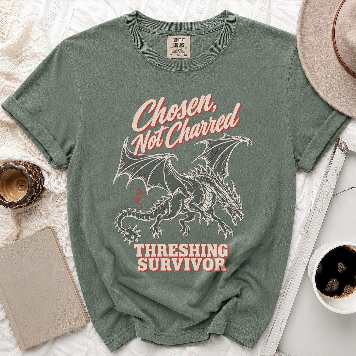Green t-shirt with a dragon graphic and text "Chosen, Not Charred Threshing Survivor."