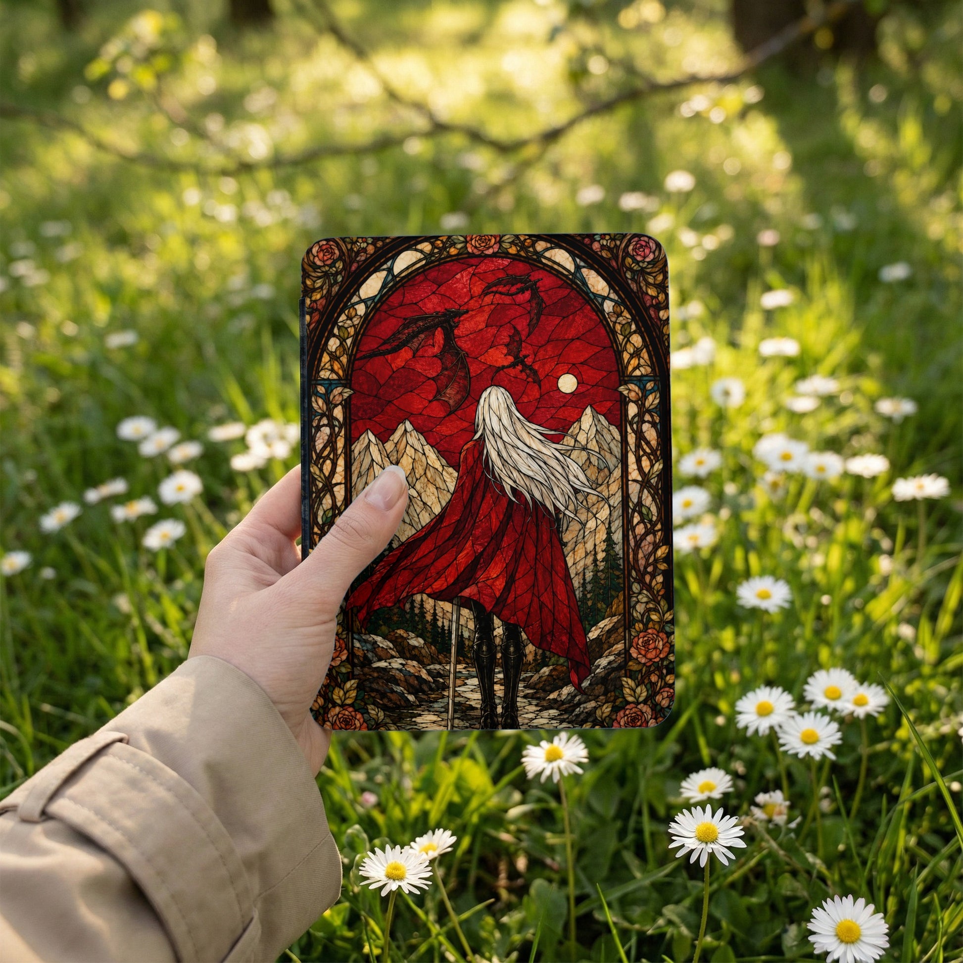 Woman holding a stained glass design featuring a dragon and hooded figure.