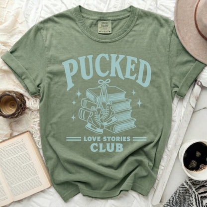 Green t-shirt with "PUCKED LOVE STORIES CLUB" graphic and ice skates.