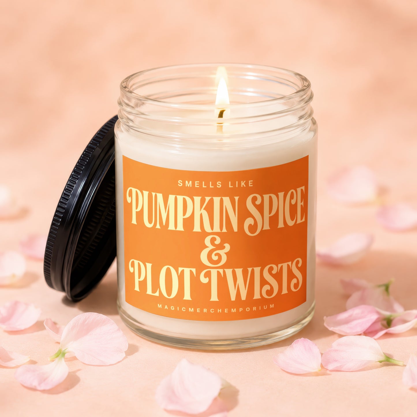 Candle with orange label reading "Smells Like Pumpkin Spice & Plot Twists".