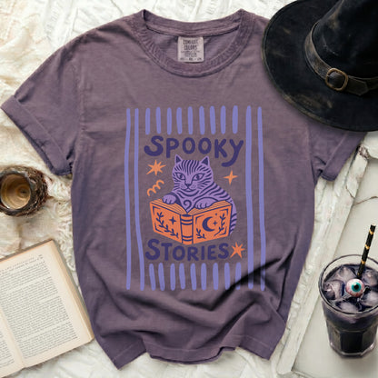 Purple t-shirt with "Spooky Stories" and a cartoon cat reading a book.