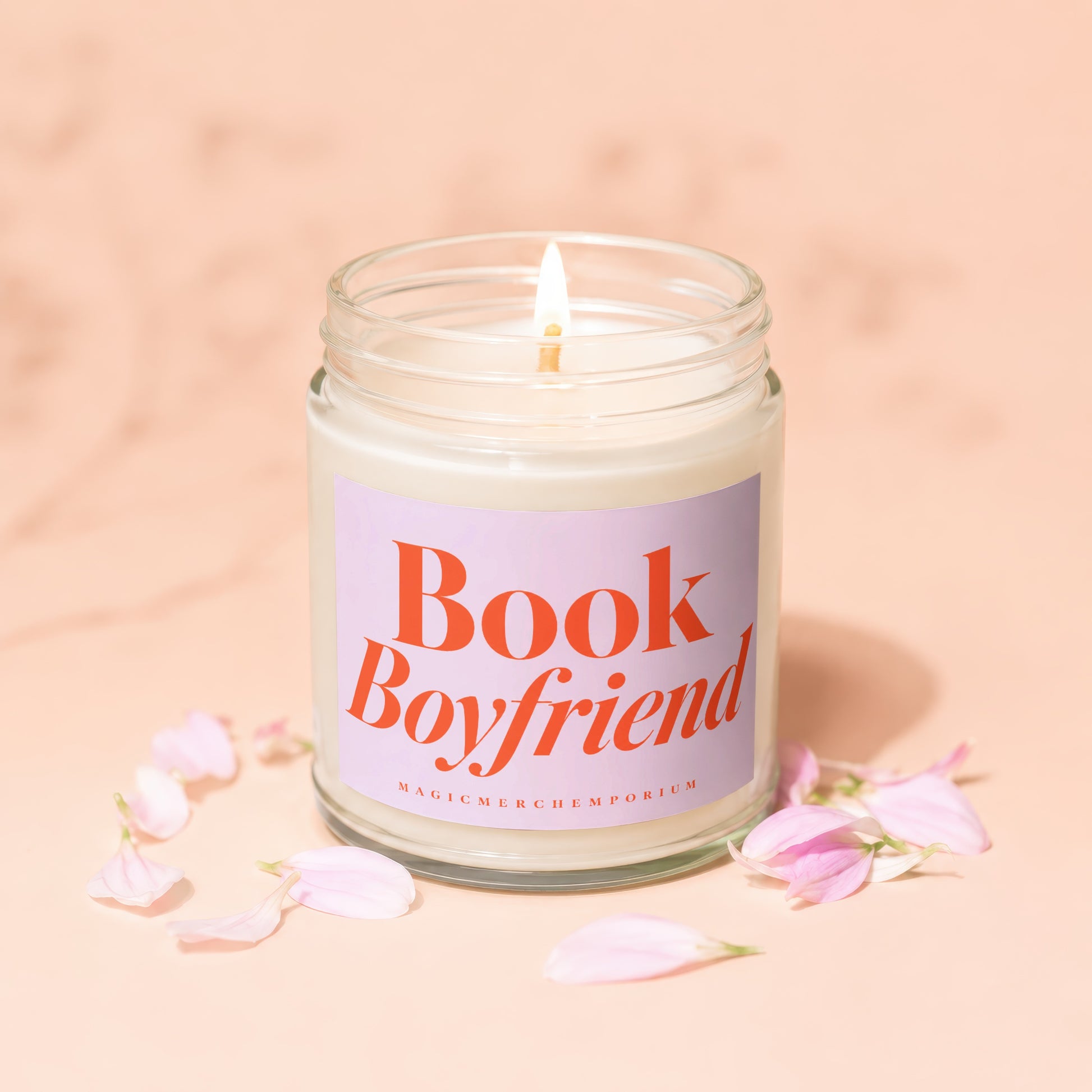 Lit candle in glass jar with "Book Boyfriend" label and pink petals