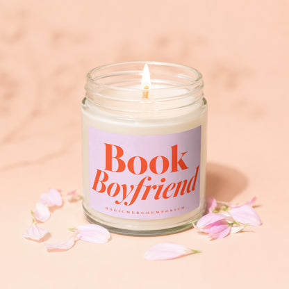 Lit candle in glass jar with "Book Boyfriend" label and pink petals