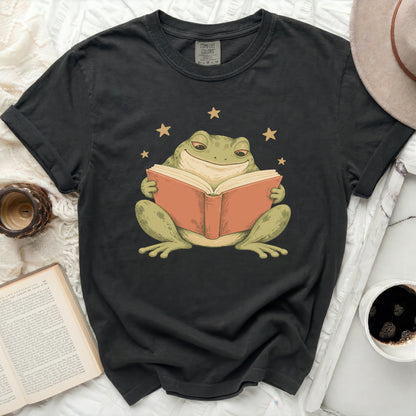 Frog reading a book with stars on a black t-shirt.