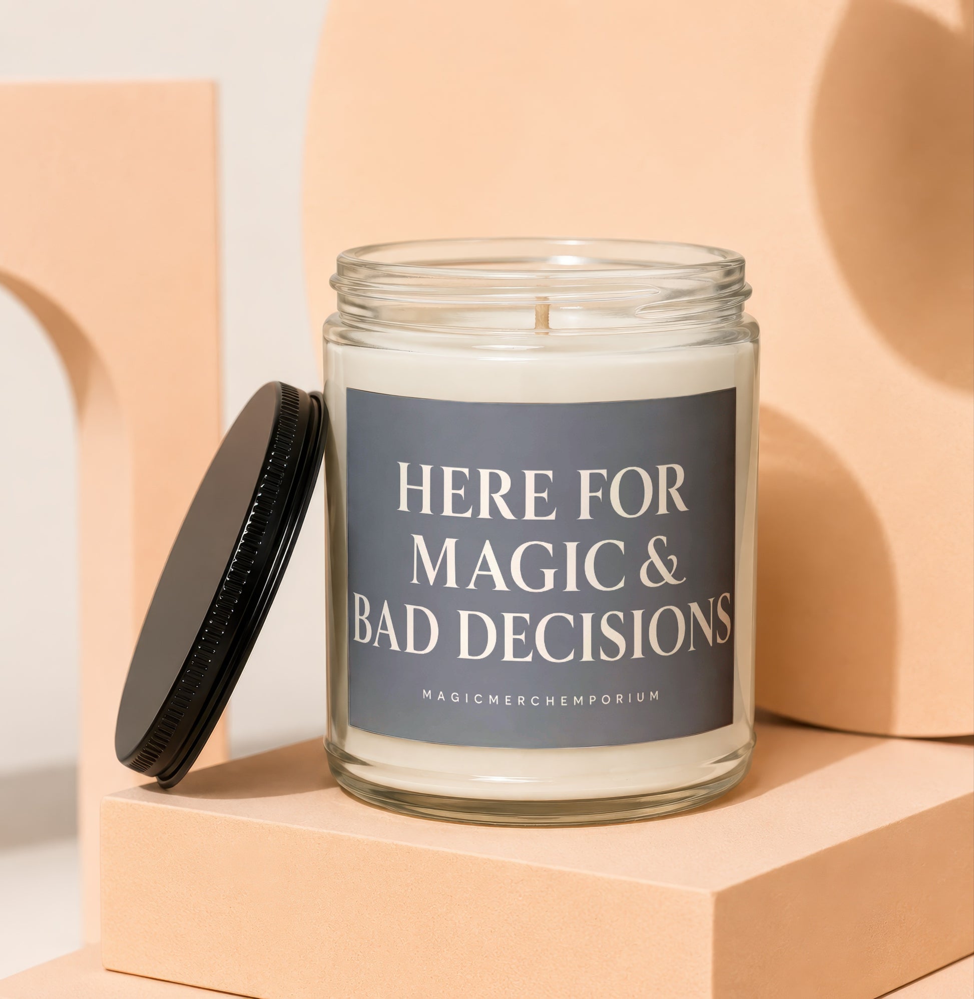 Glass jar candle with label reading "Here for Magic & Bad Decisions."