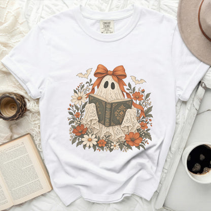White t-shirt with a graphic of a lace ghost reading a book.
