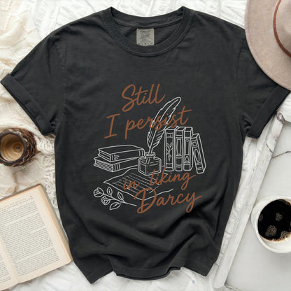 Black Comfort Colors t-shirt with "Still I persist in liking Darcy" text and illustrations.