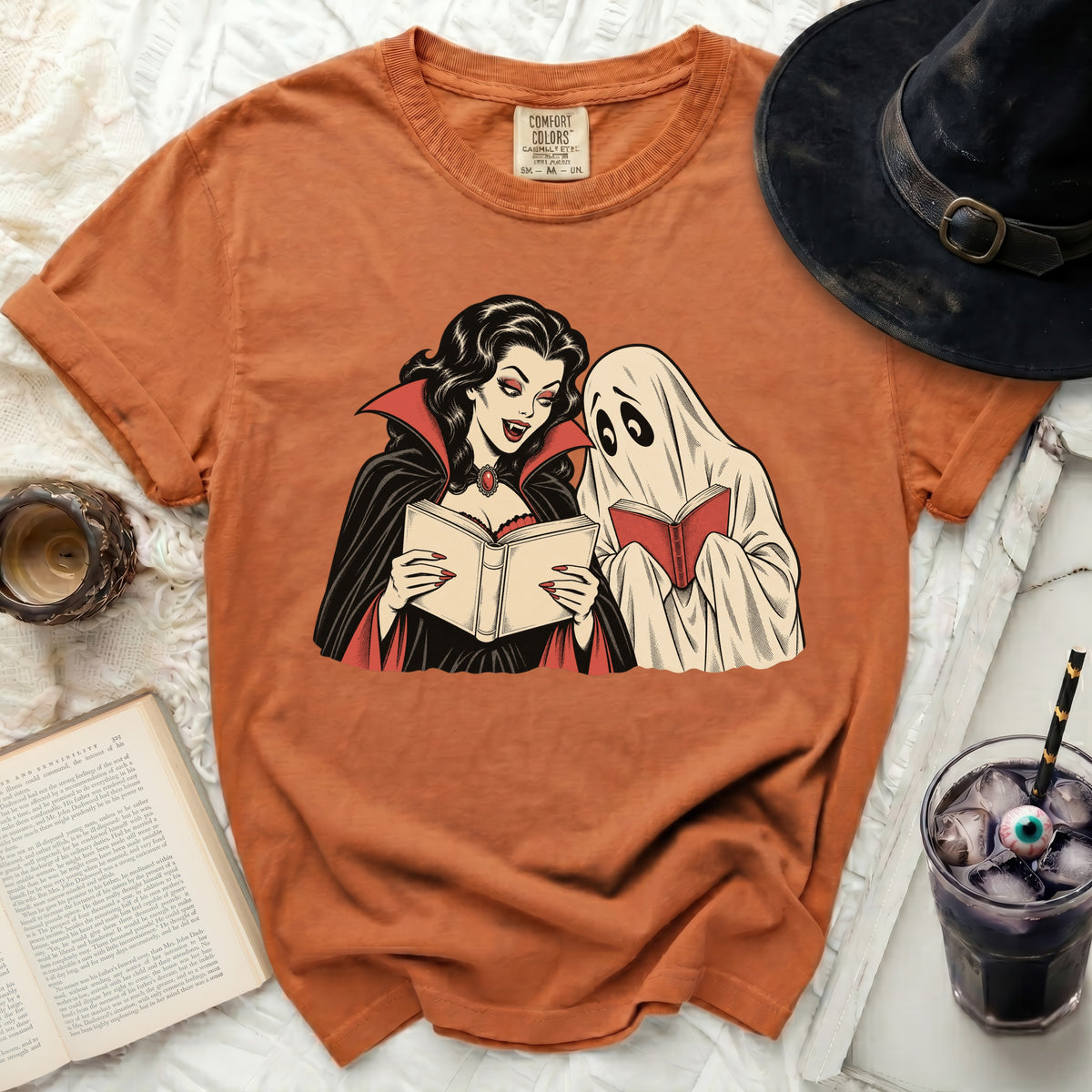 Vampire and ghost reading books on an orange t-shirt.