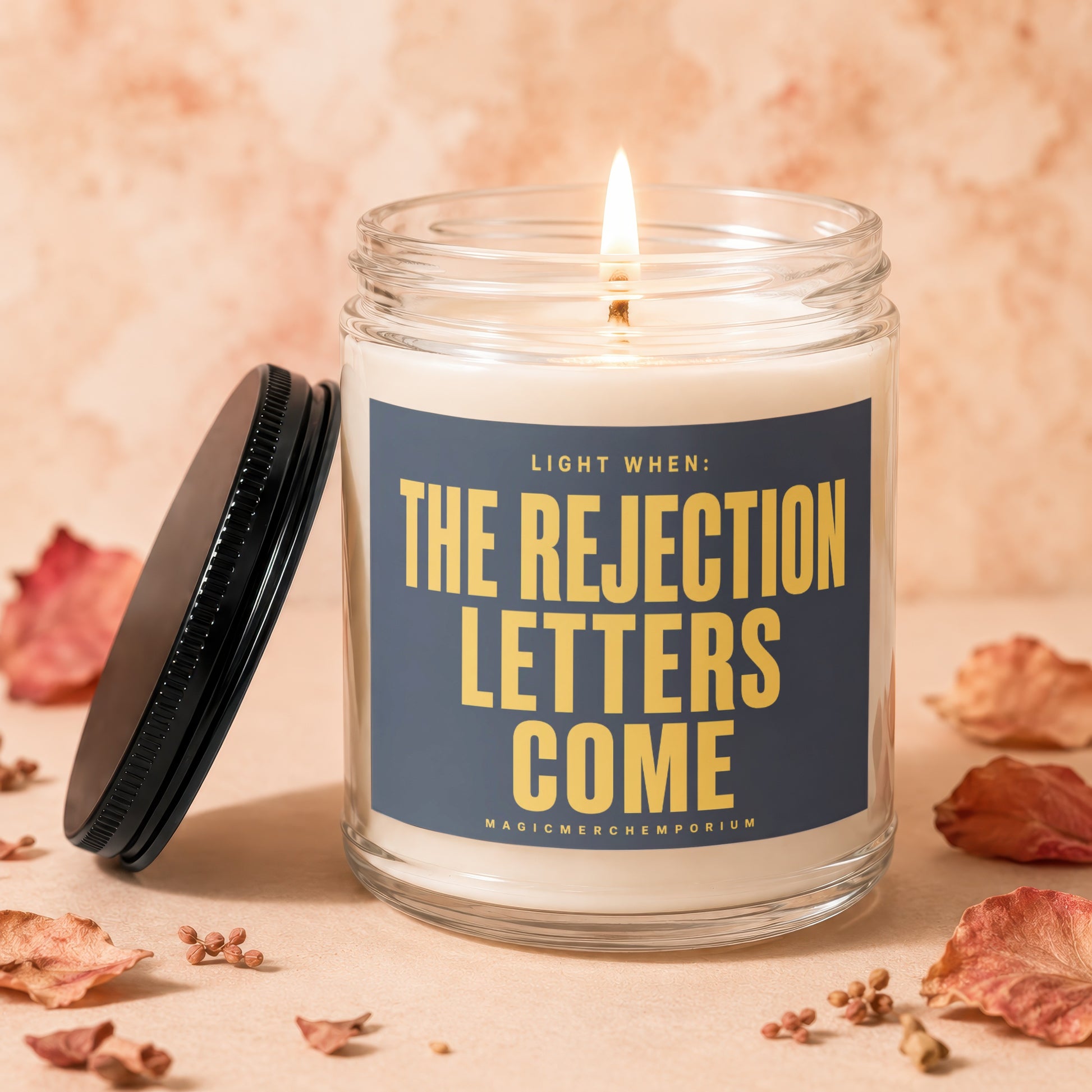 Lit candle in glass jar with label "Light When: The Rejection Letters Come".