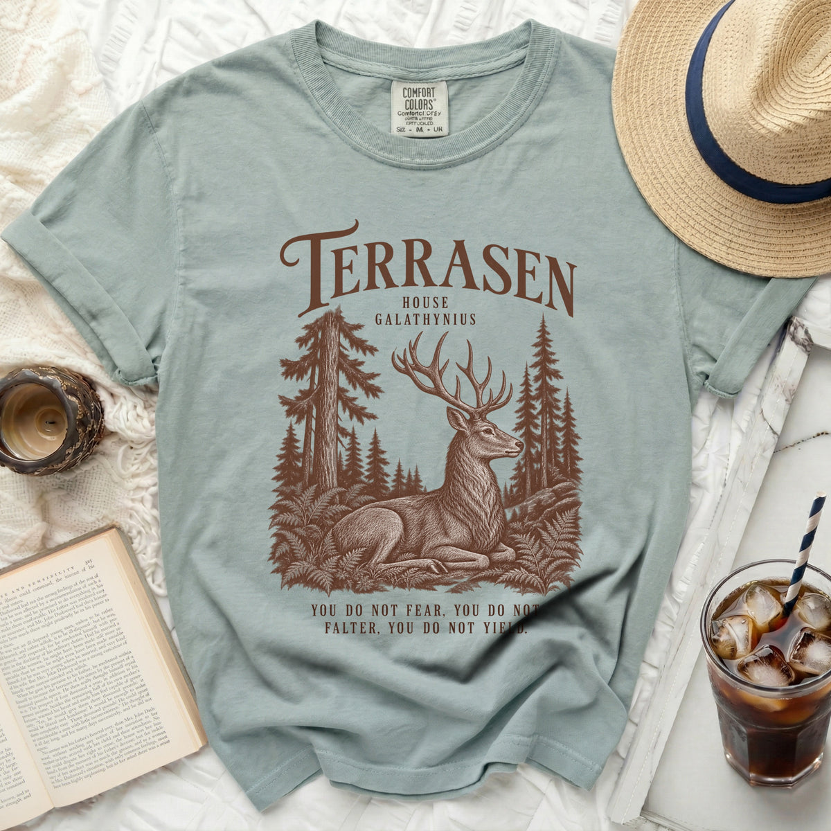 Light blue t-shirt with Terrasen House Galathynius deer forest graphic and quote.