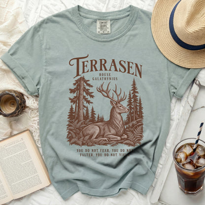 Light blue t-shirt with Terrasen House Galathynius deer forest graphic and quote.