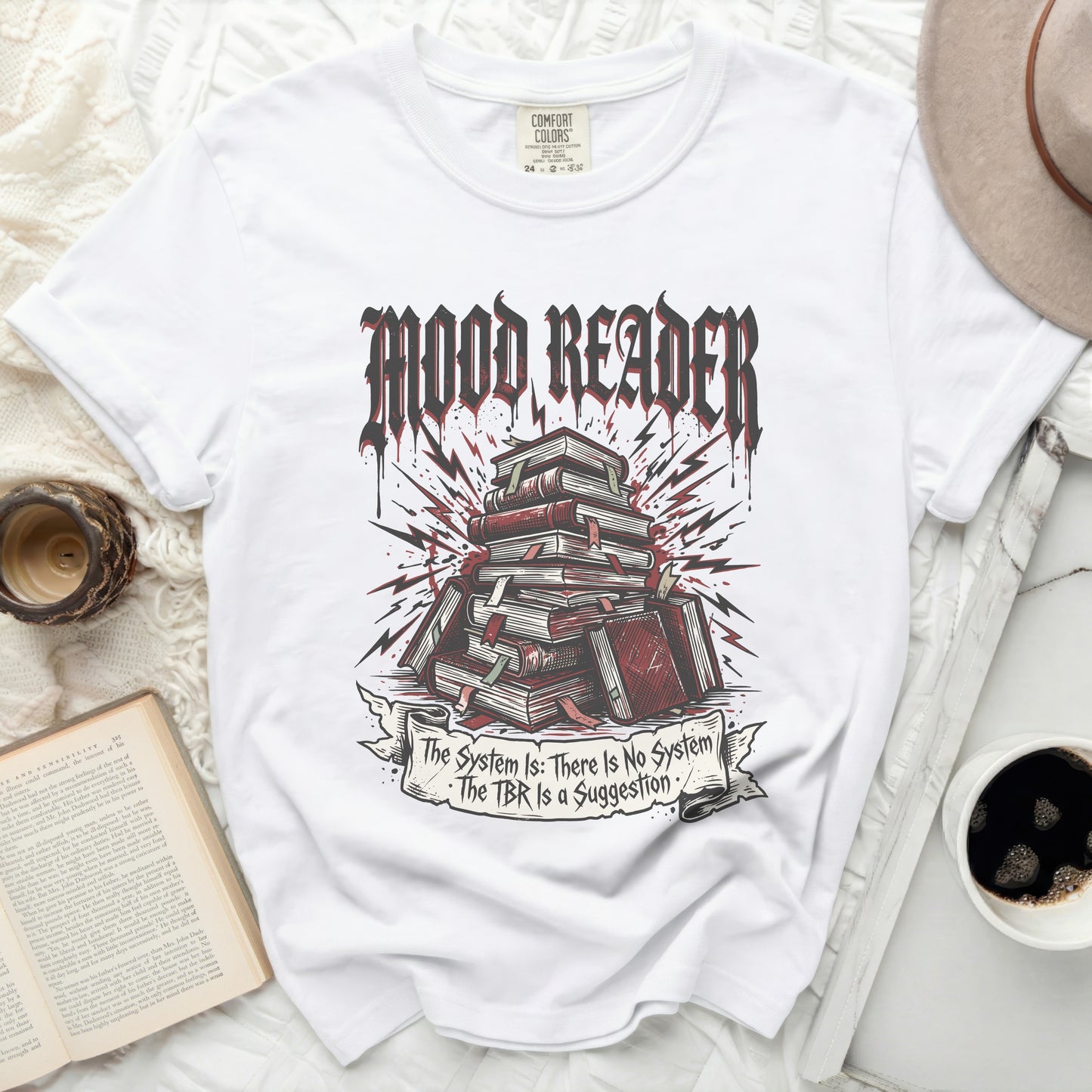 White t-shirt with "MOOD READER" and book pile graphic, with text.