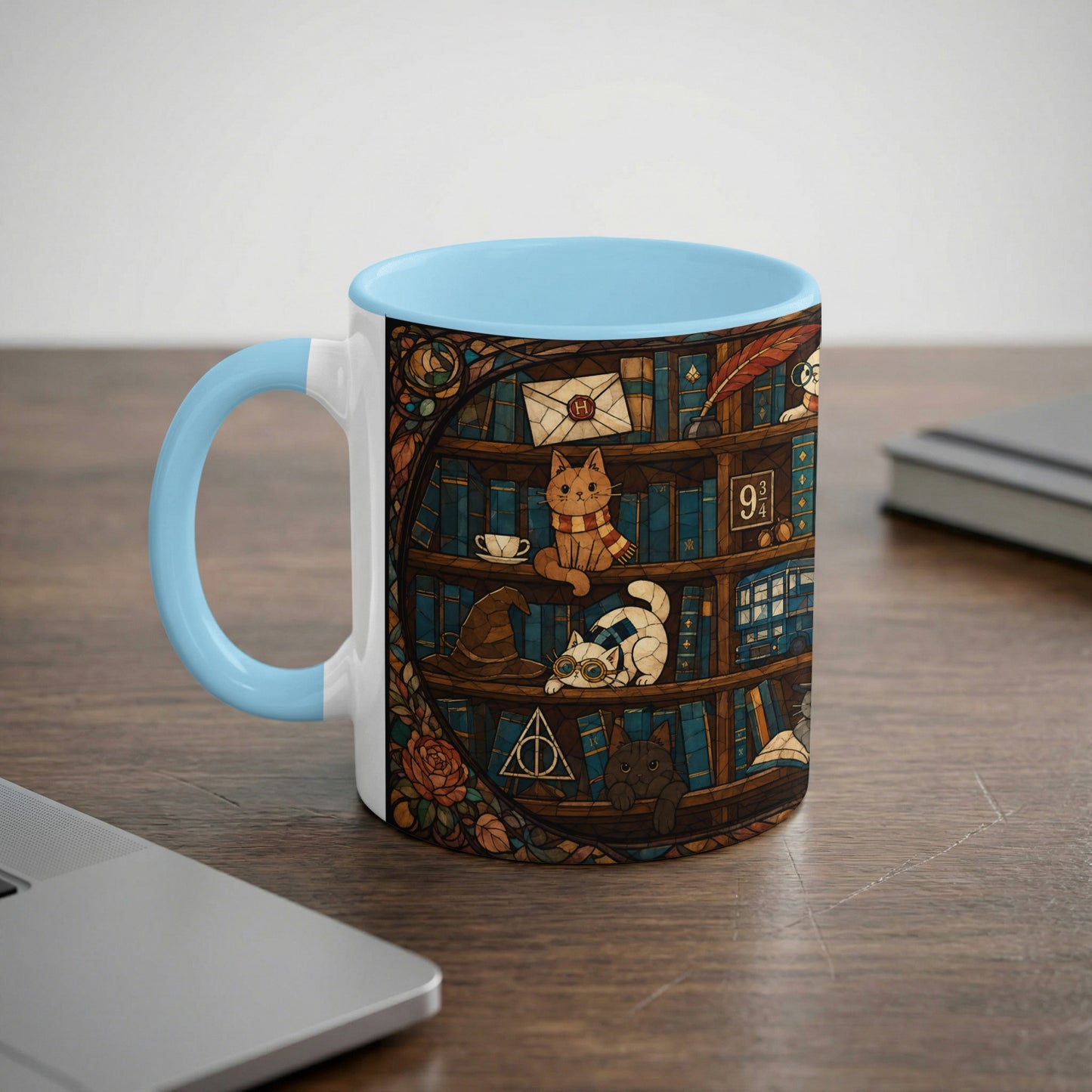 White mug with blue handle featuring a stained-glass design of cats on bookshelves.